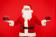 © satyrenko - Photo of Santa Claus gloved hands holding red giftbox