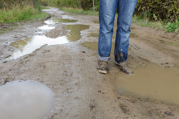 Man in dirty shoes standing in the mud