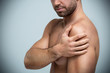 © pikselstock - Guy holding his shoulder in pain
