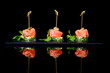 canapes with salmon and capers on black background