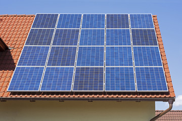 Solar Panels on the Red House Roof. Solar Energy Background.