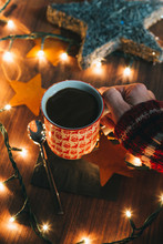 Hands Holding A Cup Of Hot Chocolate With Christmas Lights