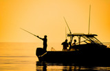 Fototapeta Góry - silhouette of sport fishing boat reflecting on calm water