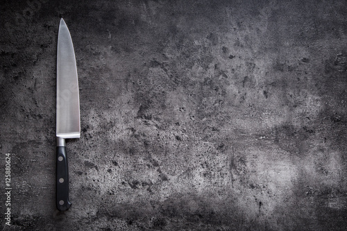Fotografía Kitchen knife on concrete or wooden board.