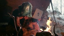 Prehistoric Caveman Using Laptop