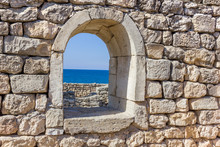 Ancient Stone Wall With A Window And A View Of The Sea