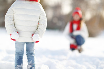 happy family mother and child daughter having fun, playing snowb