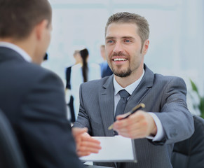 Businessman giving a pen to seal  deal with his partner