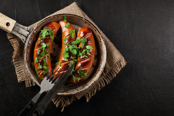 Canvas Print - Fried sausage on an old pan