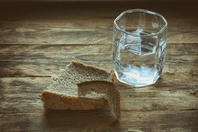 Glass Of Water And Hunk Black Bread
