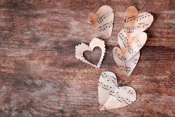 Sticker - Paper hearts with music notes on wooden background