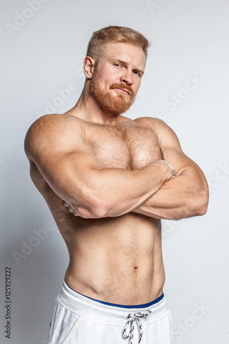 young caucasian muscular bearded man isolated on studio background Poster