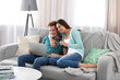© Africa Studio - Happy couple with credit card sitting on sofa and making online shopping