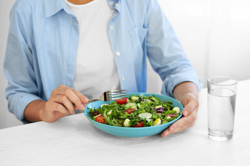 Poster - Woman eating fresh delicious salad at table