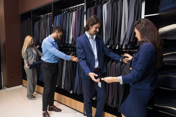 Wall Mural - Handsome Business Man And Woman Fashion Shop, Customers Choosing Clothes In Retail Store Young People Shopping Formal Wear