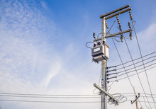 Transformers, Power Electric Pole On The Bright Sky. The Equipment Used To Raise Or Lower Voltage, High