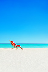 Christmas Santa Claus relaxing in sunlounger at ocean tropical beach