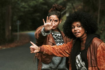 two girls making funny hitchhiking