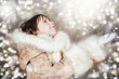 Happy little girl in warm clothes on the christmas background