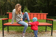 © Dmitry Elmarovich - A small child helps to tie the shoes of his mother in the Park