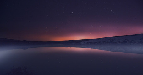 Morning dawn on a starry background sky reflected in the water o