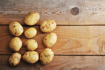 Wall Mural - raw new potatoes in the skin on rustic wooden background