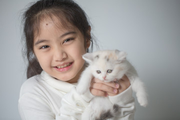 Wall Mural - Happy little Asian girl hugging lovely scottish fold kitten