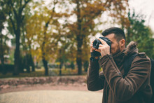 Man Photographer Taking Photo In The Autumn Park