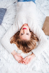 Sticker - Woman wearing red lipstick and sweater lying on the carpet