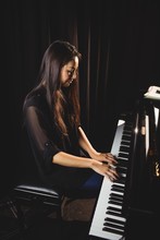 Woman Playing A Piano In Music Studio