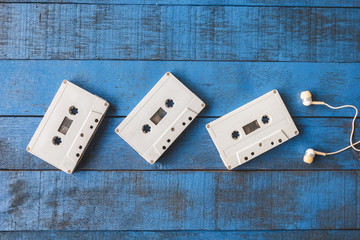 Top view of  Audio tape with earphones on blue wooden table 