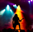 © DWP - silhouette of guitar player in action on stage in front of concert crowd