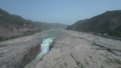 Wall Mural - aerial drone shot flying over the hukou waterfalls, a narrow stretch of the yellow river in china