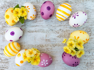 Easter eggs and yellow primrose flowers frame