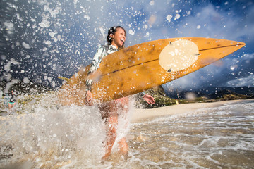 Wall Mural - surfing girl with surfboard in water splashes