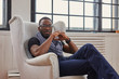 © Fxquadro - Black male in sunglasses relaxing on lounge armchair.