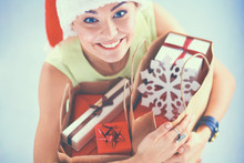 Smiling Woman In Santa Hat With Many Gift Boxes On White Background