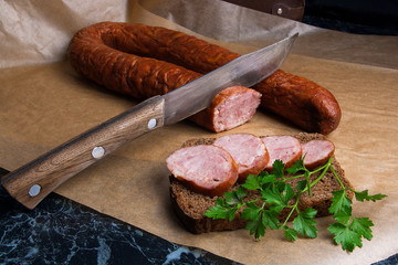 Slices of smoked sausage with spice, herbs and vegetables on the