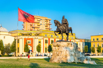 Skanderbeg square with flag, Skanderbeg monument and The Et'hem Bey Mosque in the center of Tirana city, Albania.