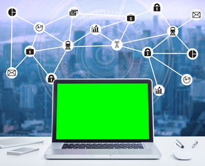 Blank green screen laptop computer with night cityscape and digital technology diagram concept