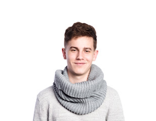 Wall Mural - Teenage boy in gray sweater and scarf. Studio shot, isolated.