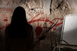 © kolotype - Shadowy female figure holding blade near blood stained wall