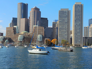 A view of the Boston skyline with boats in the foreground.