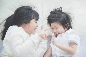 Wall Mural - Cute asian children lying on white bed