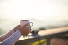 Woman Drinking Coffee In Sun Sitting Outdoor In Sunshine Light Enjoying Her Morning Coffee, Vintage, Soft And Select Focus