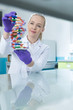 © Myvisuals - Woman scientist holding DNA molecule