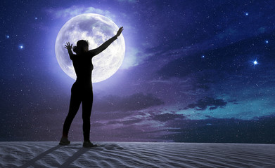 female silhouette with outstretched arms in the moonlight