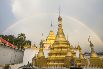 Rainbow over Golden Pagoda at Wat Thai Watthanaram in the evening light, Mae Sot, Tak, Thailand