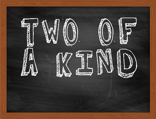 TWO OF A KIND handwritten text on black chalkboard