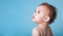 Cute Baby Girl Looking Up Against Vivid Blue Background